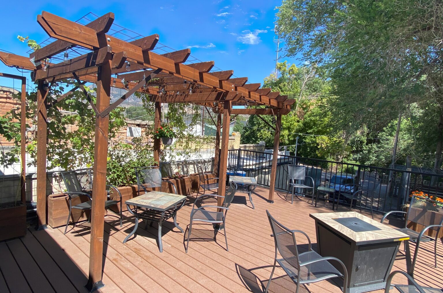 Outdoor tables beneath the wooden pergola on The Haven Coffee House deck